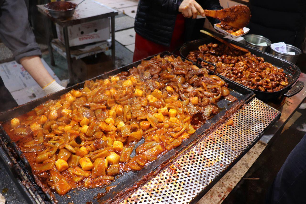 韓國傳統甜點在夜市攤位上製作中，吸引路人紛紛駐足